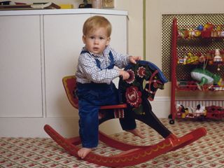 Prince Harry on a rocking horse in the playroom at Kensington Palace, London, 22nd October 1985