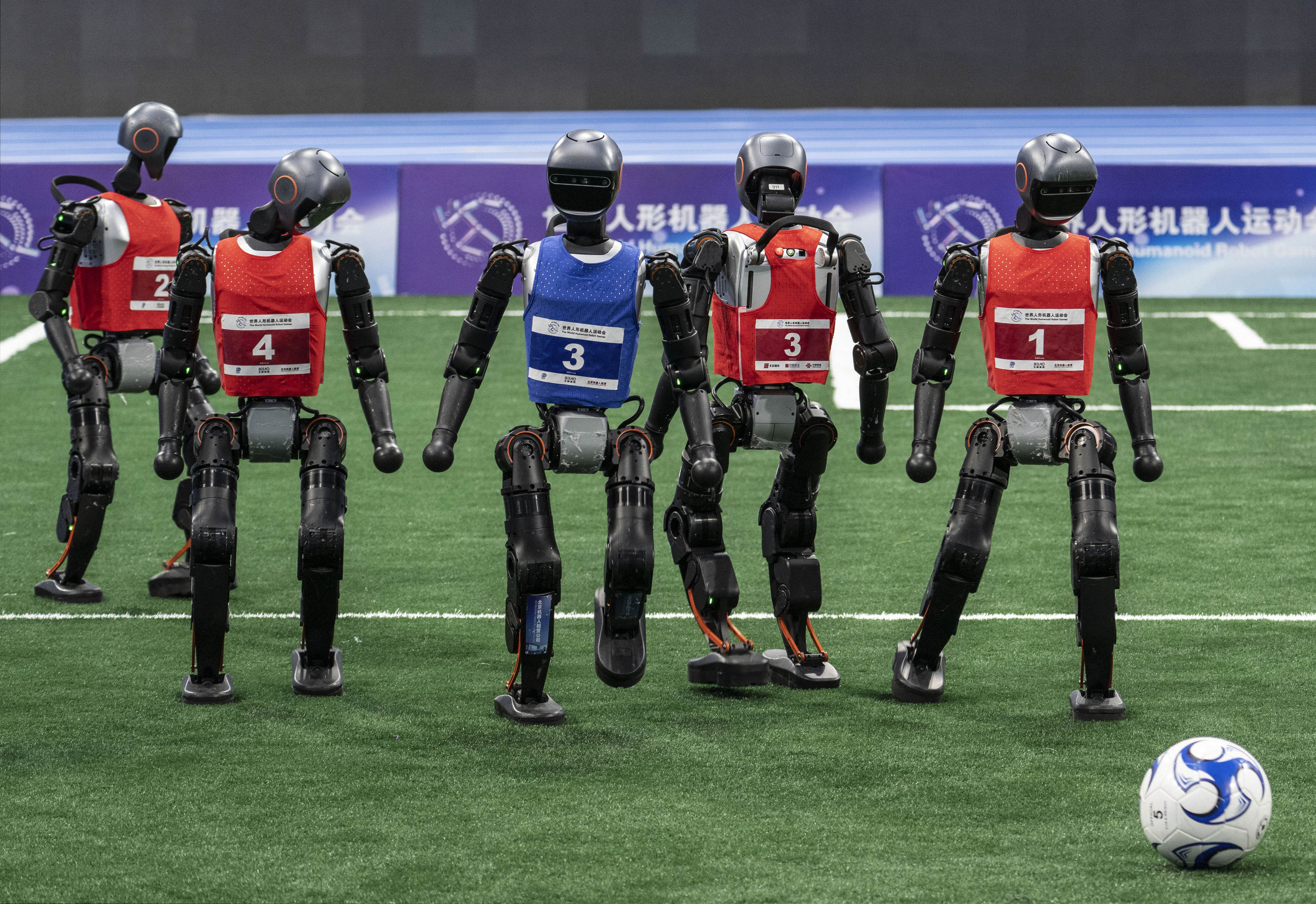 A photograph of humanoid robots playing soccer at the World Humanoid Robot Games. 