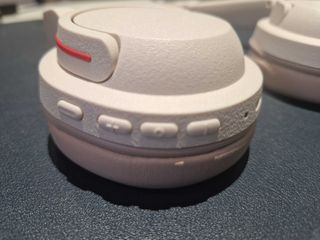 An off-white pair of BonoBeats Lite headphones sitting on a table