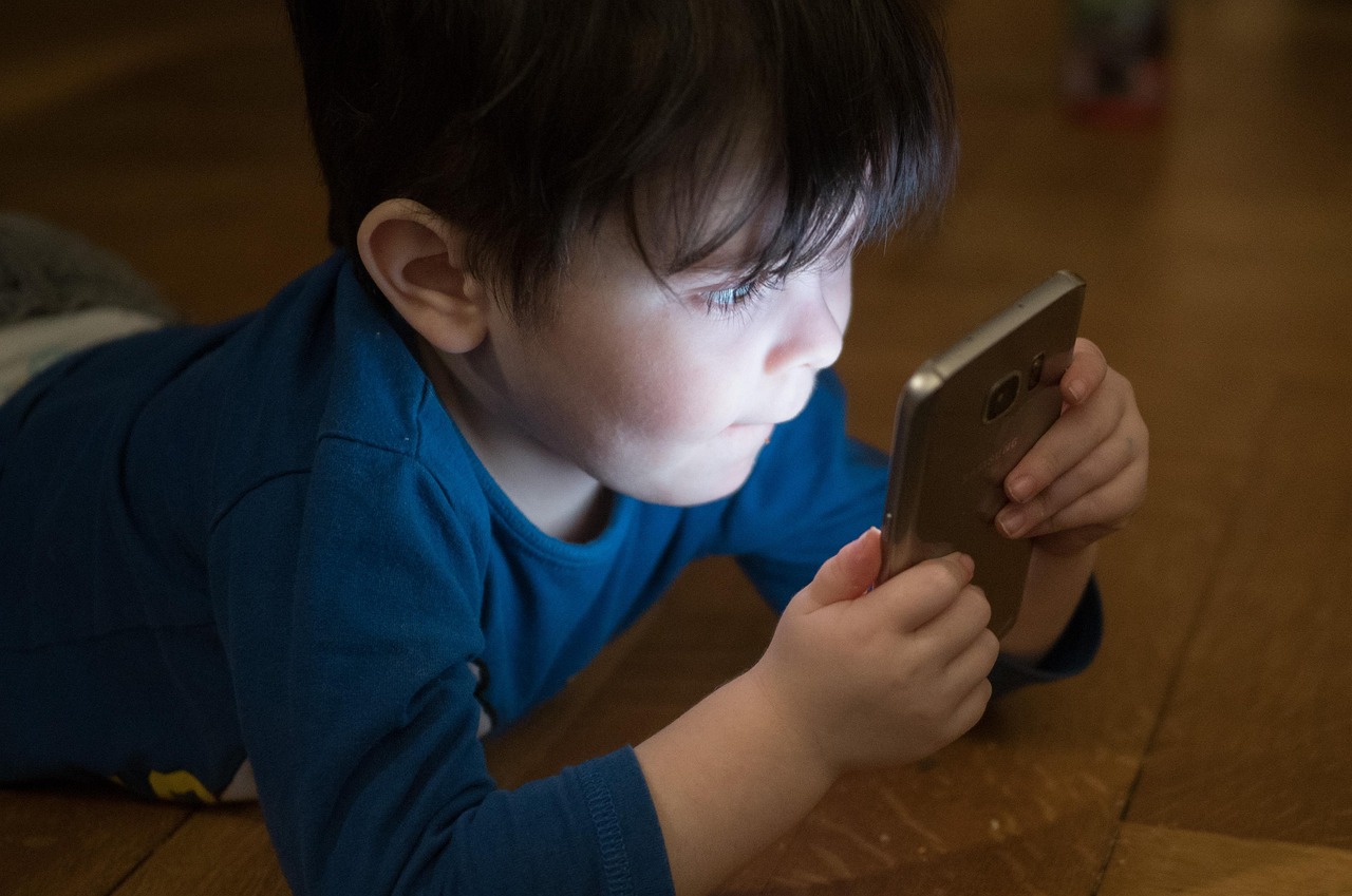 A boy looking at a cell phone screen