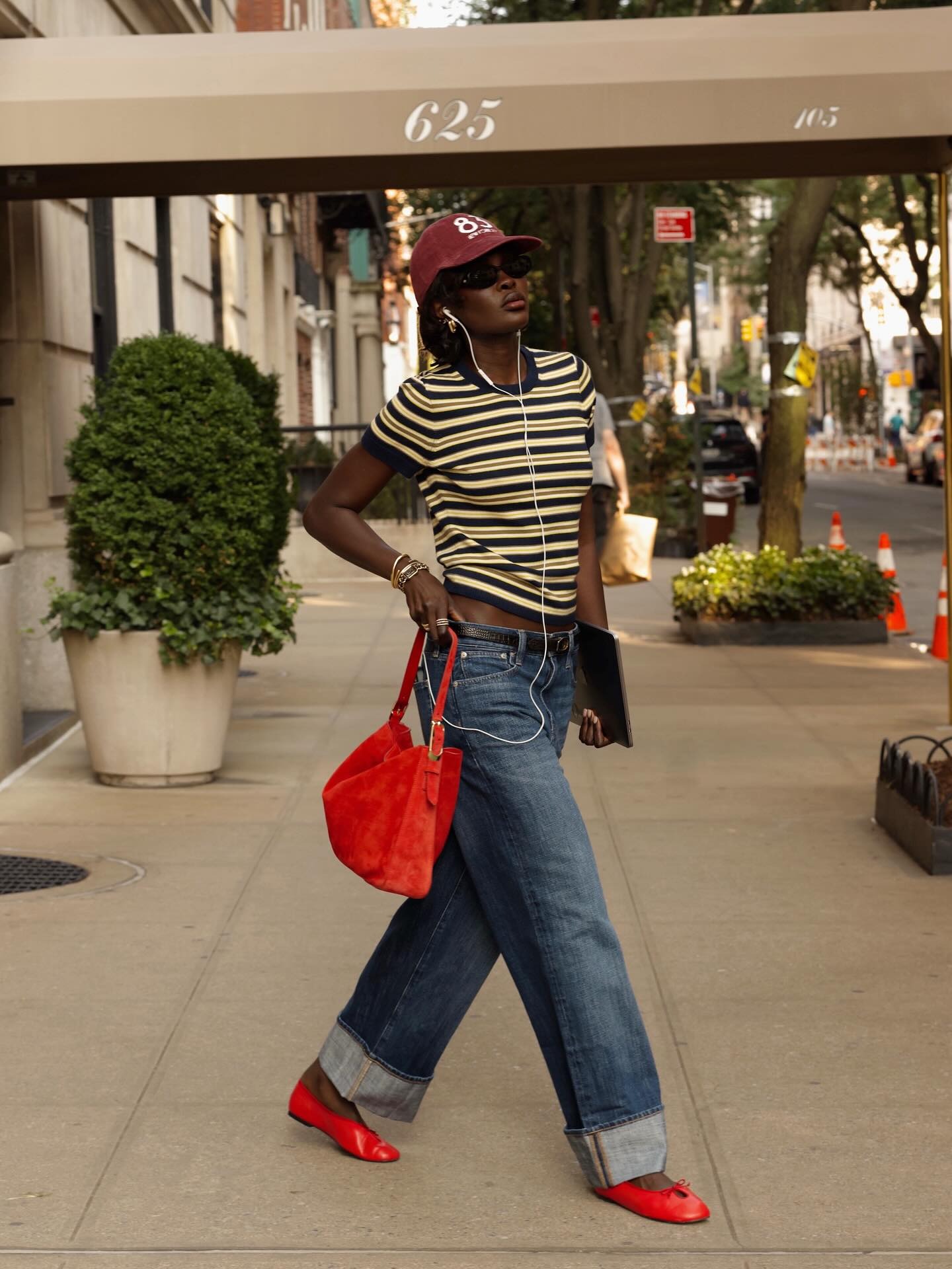 Influencer wearing a striped tee, jeans, and red ballet flats