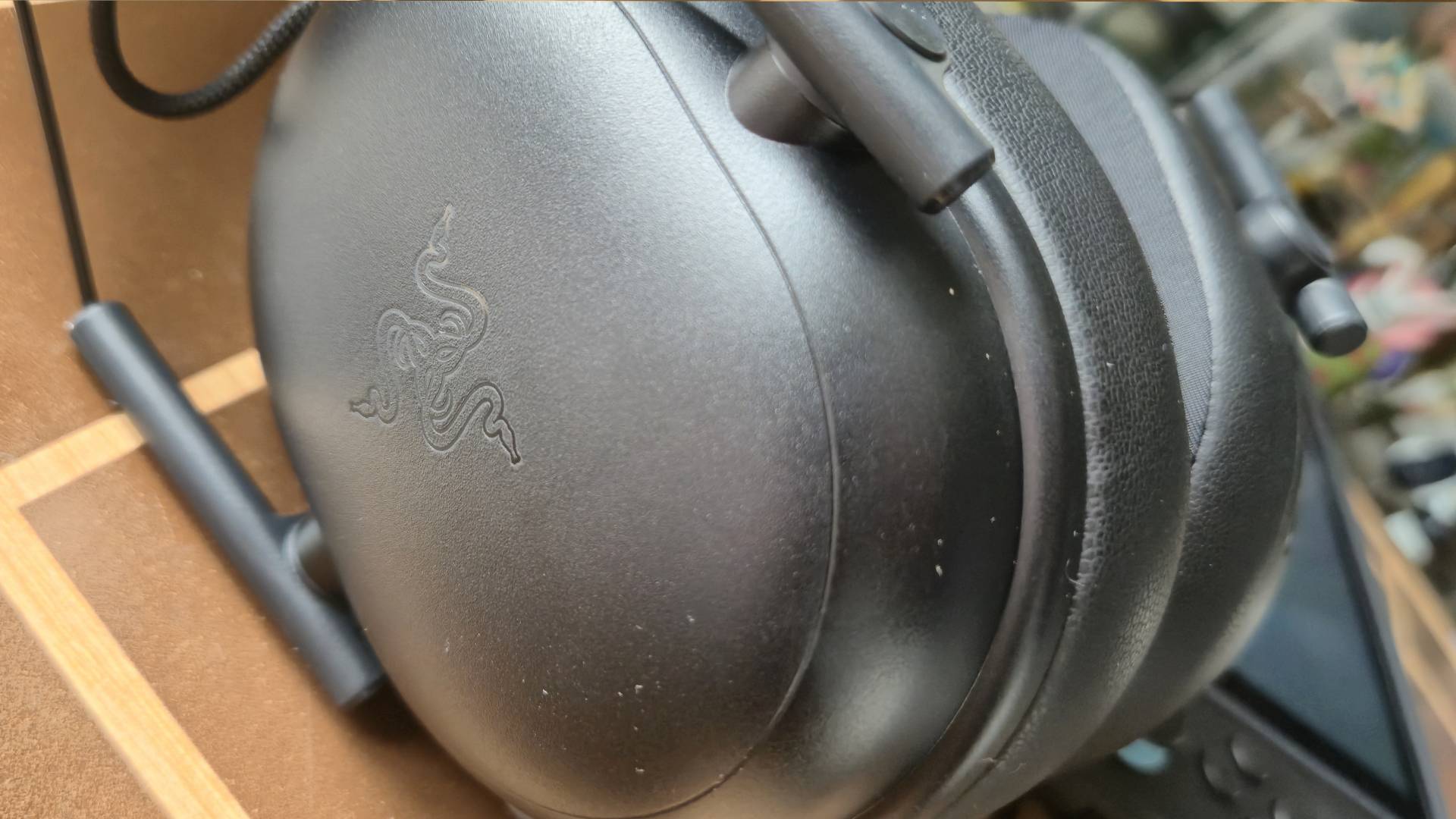 Photo by Rosalie Newcombe of a close up of the Razer logo on the left cup of the BlackShark V3 X HyperSpeed headset.