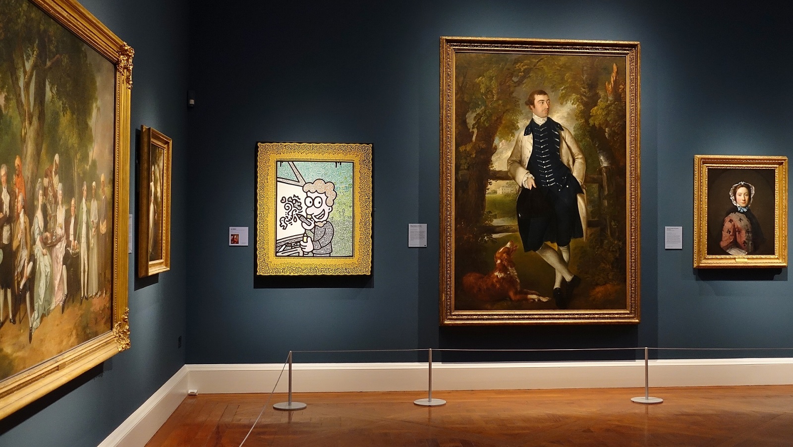 A self-portrait by Mr Doodle, featuring a cartoon man with red curly hair smiling whilst painting on a canvas, is in a smart art museum next to old colourful paintings