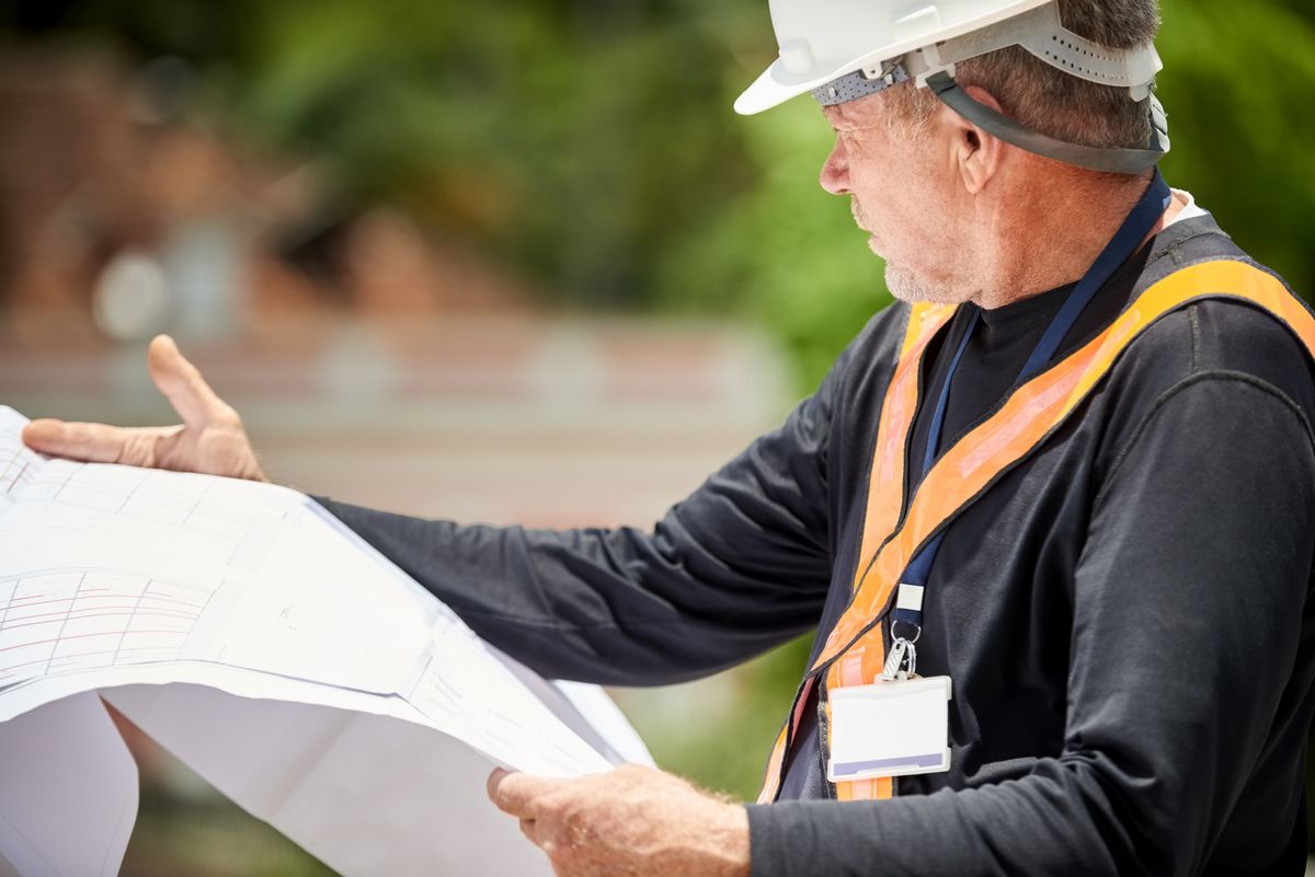 Project manager looking at blueprints