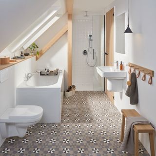 Geometric bathroom floor tiles in white bathroom with sloping ceiling
