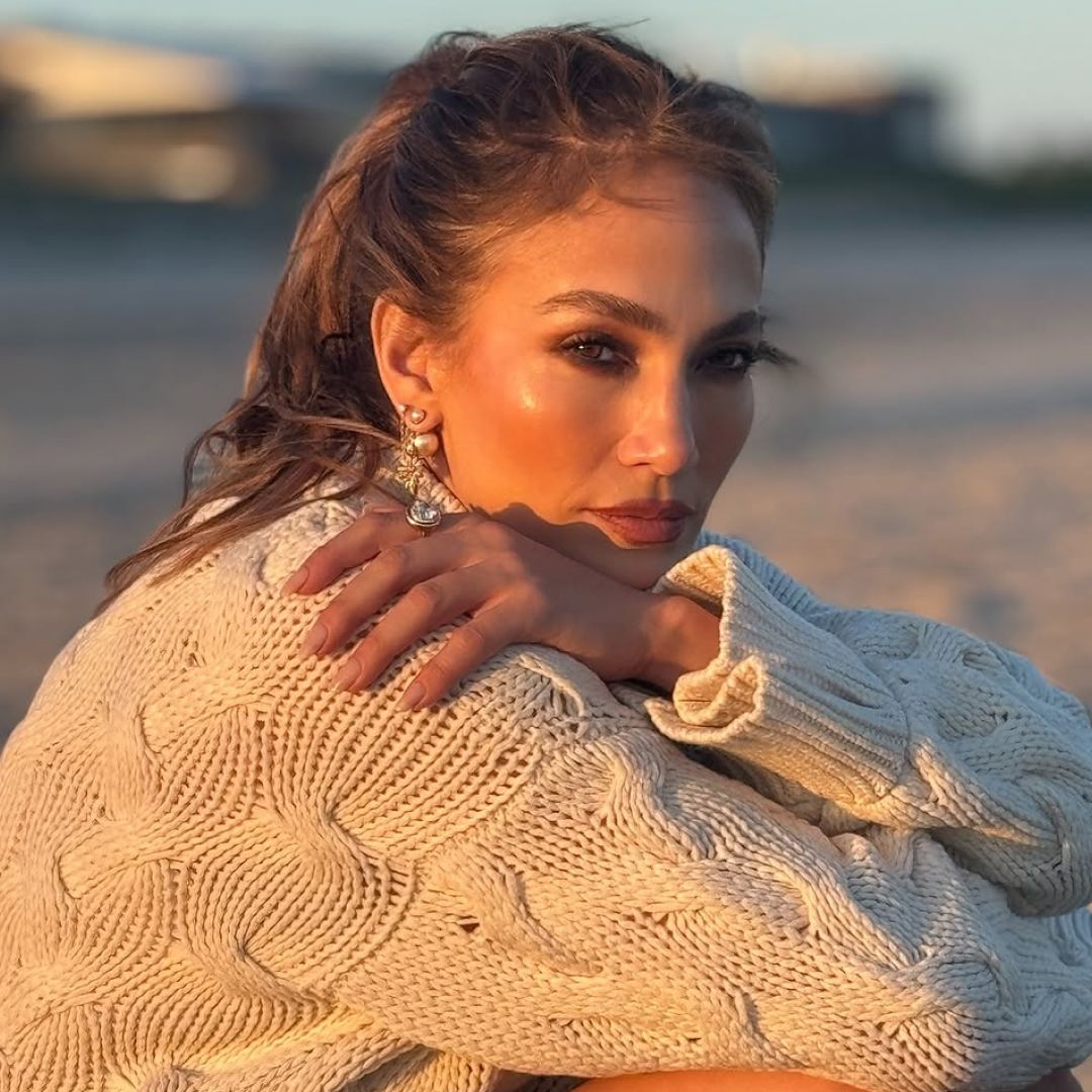 Jennifer Lopez posted on Instagram in a cardigan, lace bloomers/skirt, and lace-up knee-high boots