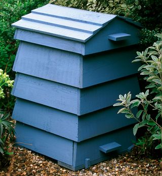 garden with blue colour wooden compost bin