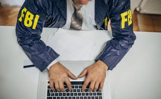 An FBI agent typing on a computer