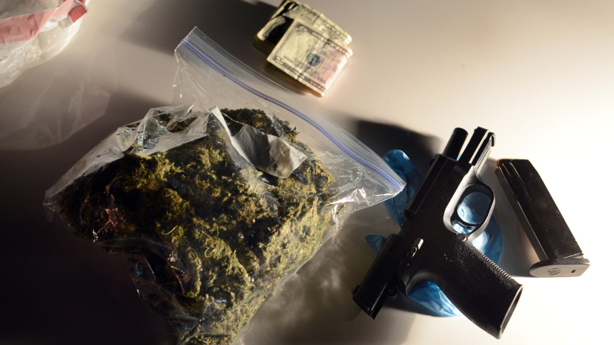Money, marijuana, and a .40 caliber handgun sit on the hood of a PG County police car after being confiscated on Thursday, April 25, 2013, in Landover, Maryland