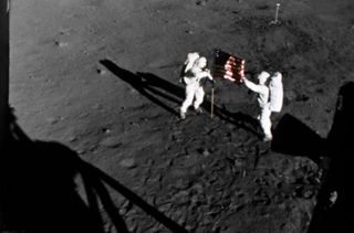 NASA astronauts Buzz Aldrin and Neil Armstrong raise the American flag on the moon during their July 20-21, 1969 moonwalk during the historic Apollo 11 lunar landing mission.