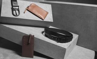 Angled concrete bricks with leather wallets and belts displayed on them.