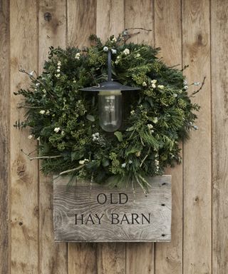 Christmas porch decor ideas with a green wreath around a light fitting
