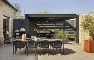 an outdoor kitchen idea using a pergola and raised platform