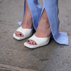 white sandals peeking out of blue trousers