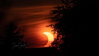 A stunning image of the rising crescent of the sun partially hidden behind the moon during the June 2021 solar eclipse.