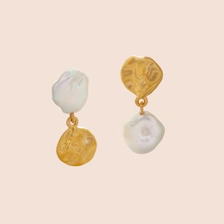 Flat lay image of Monica Vinader gold and pearl earrings