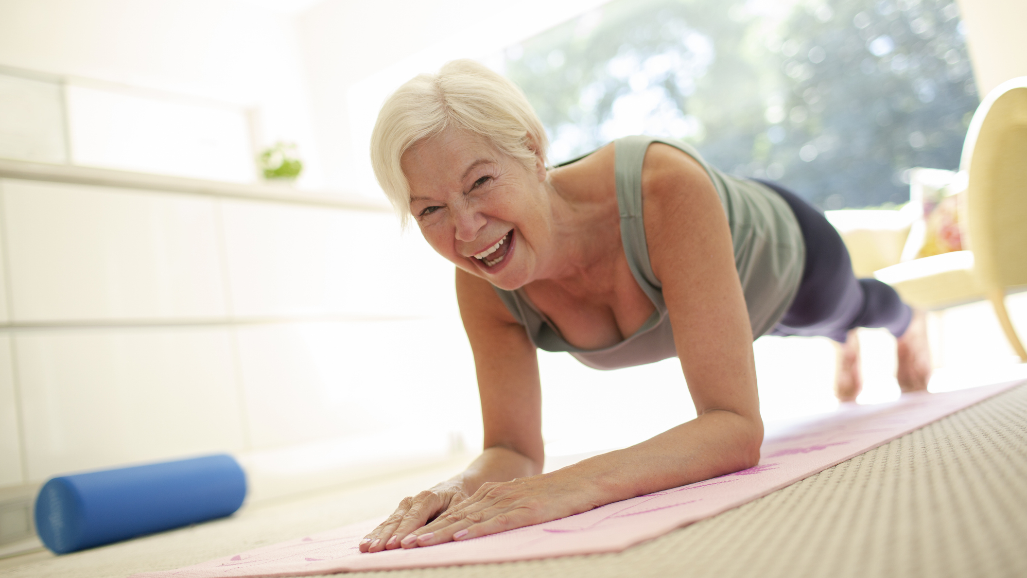 Smiling woman holding a plank position in a domestic setting