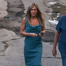 Jennifer Aniston wears a teal maxi dress with black flip flops.