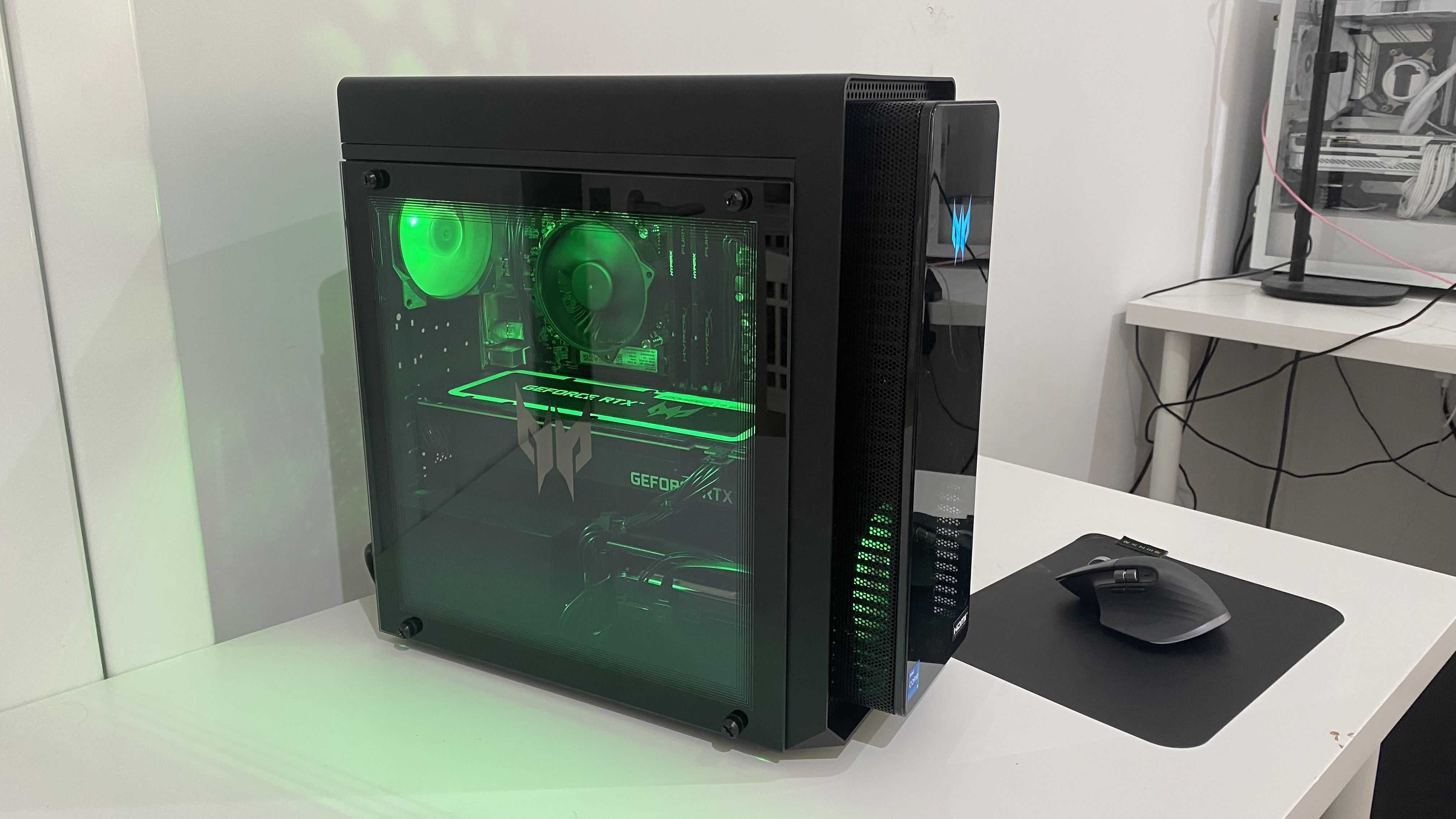 Acer Predator Orion 3000 desktop gaming PC shown side-on on a desk with RGB lighting turned on.