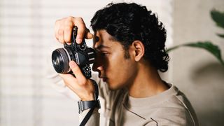 A photographer in profile, shooting with the Nikon Zf
