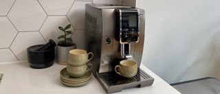 Kaffemaskinen De’Longhi Dinamica Plus med en kopp på dryppristen.