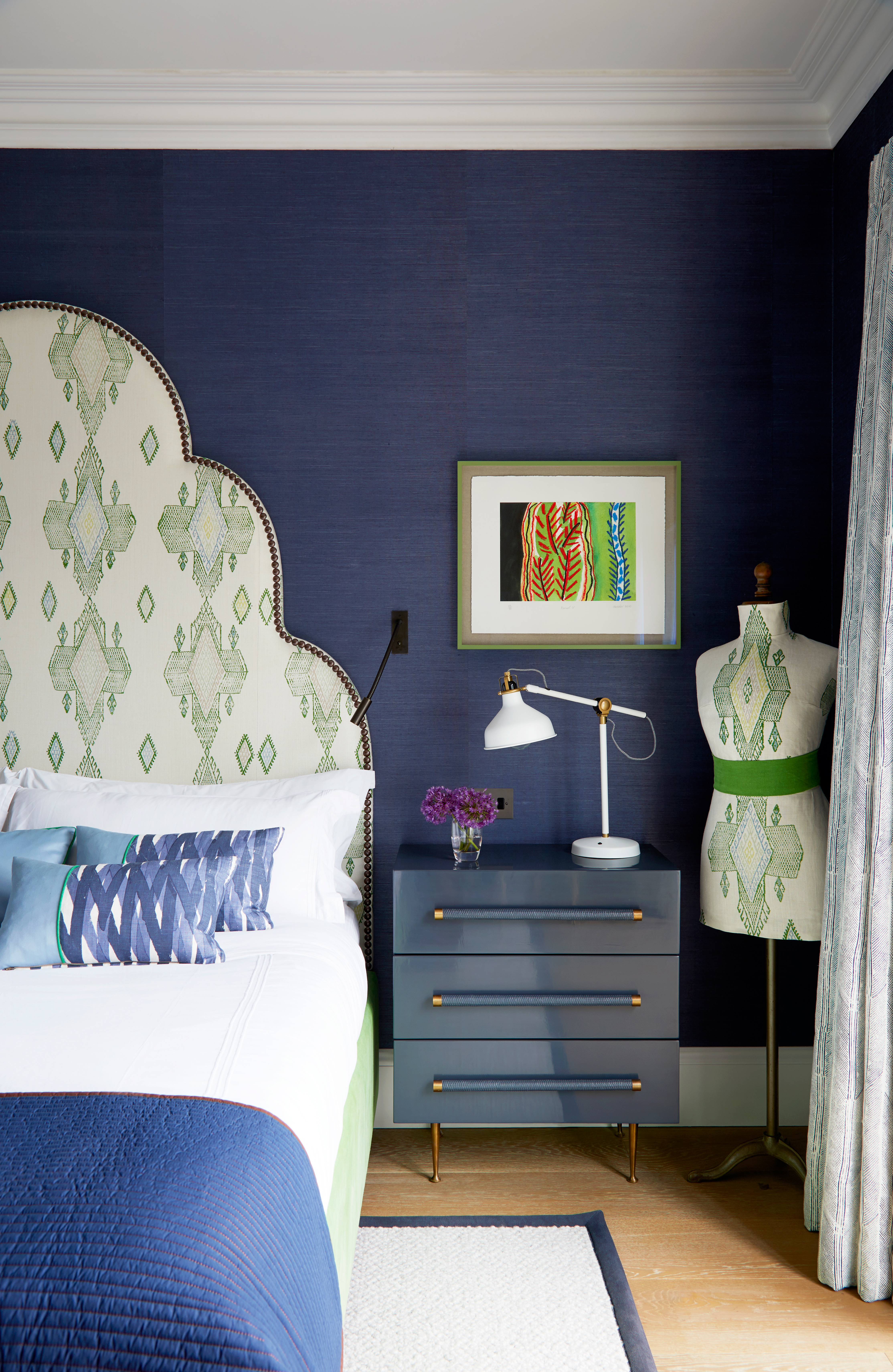 Navy blue bedroom with green patterned headboard