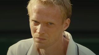 Paul Bettany prepares to hit a tennis ball in Wimbledon.