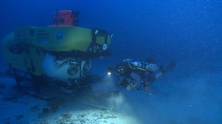 Researcher Richard Pyle uses a closed-circuit rebreather to dive deep alongside a submersible in order to explore deep coral reefs off of the Hawaiian archipelago.