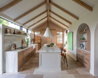 A white kitchen with limestone flooring