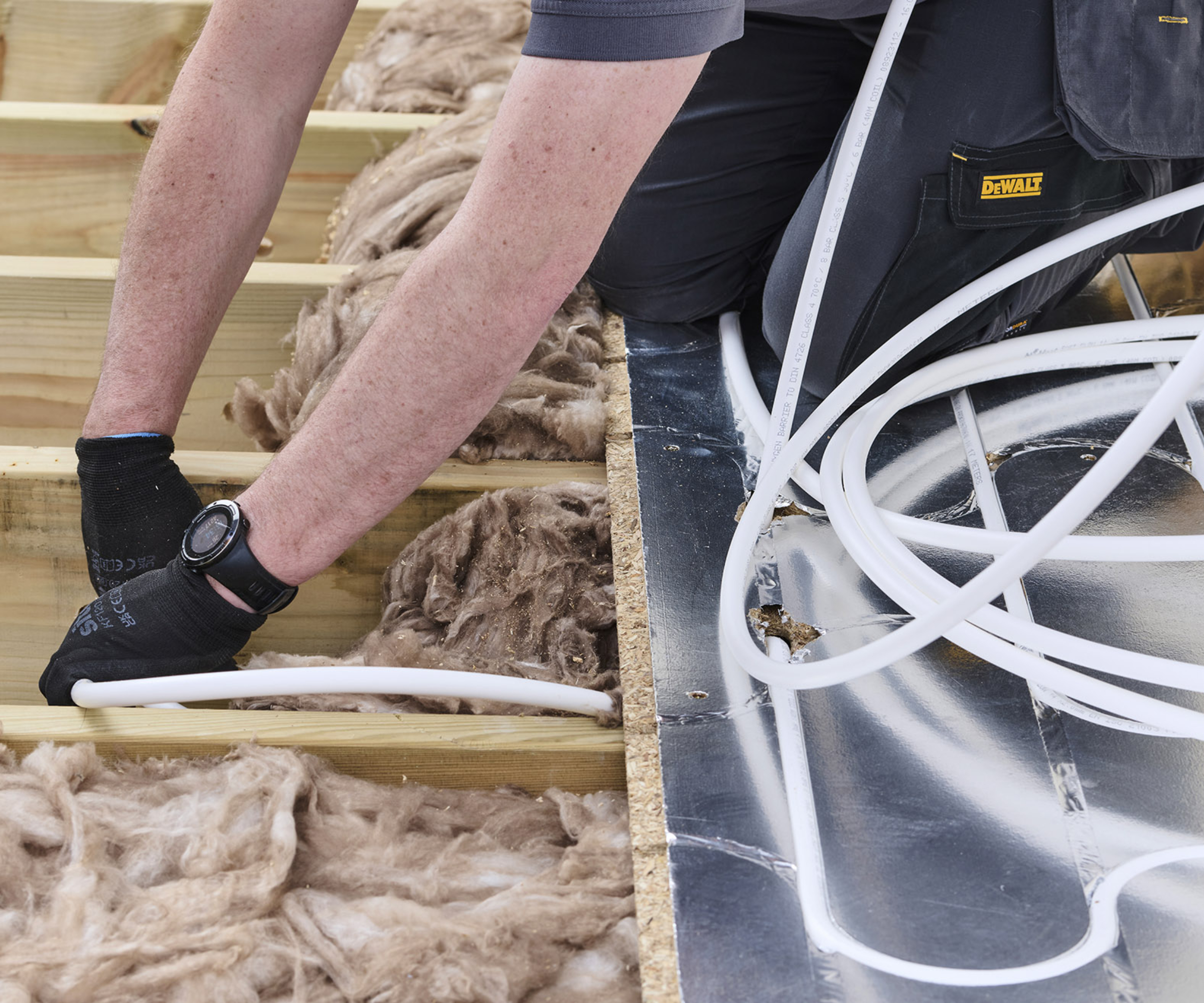 underfloor heating pipes being laid in floor