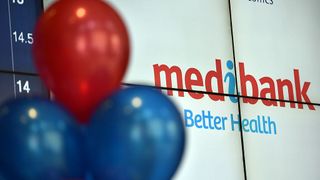 A close up of a digital display showing the Medibank logo partially obscured by red and blue balloons