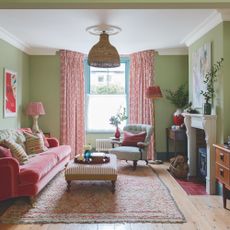 green living room with pink curtains and pink velvet sofa and midcentury cabinet
