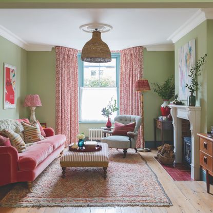 green living room with pink curtains and pink velvet sofa and midcentury cabinet