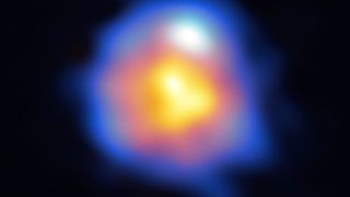 radio telescope image of a distant star, showing it as a blurry object with blue, red and orange layers.