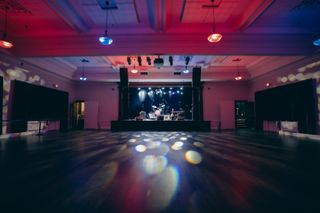 Blue, red, and purple lights shine on a live band as concertgoers stand and enjoy what WSDG helped bring to Hudson Valley’s newest live performance hub.