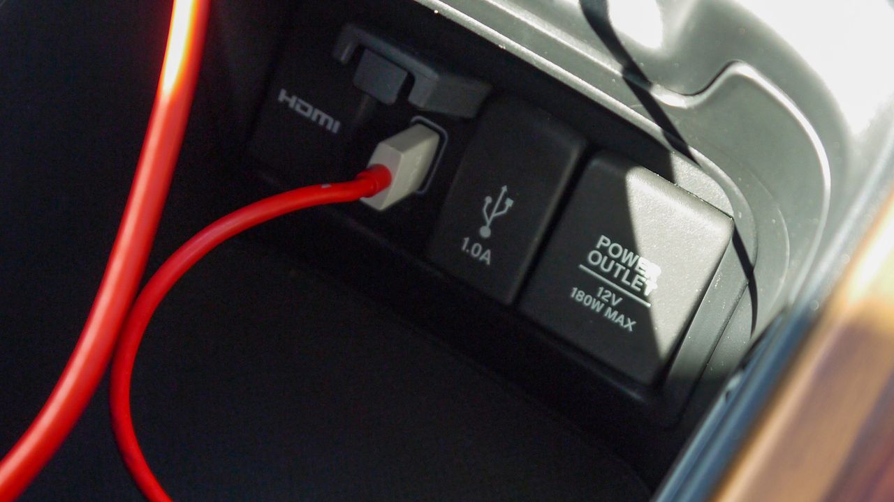 Lift the central armrest to reveal ports, including 2 x USB