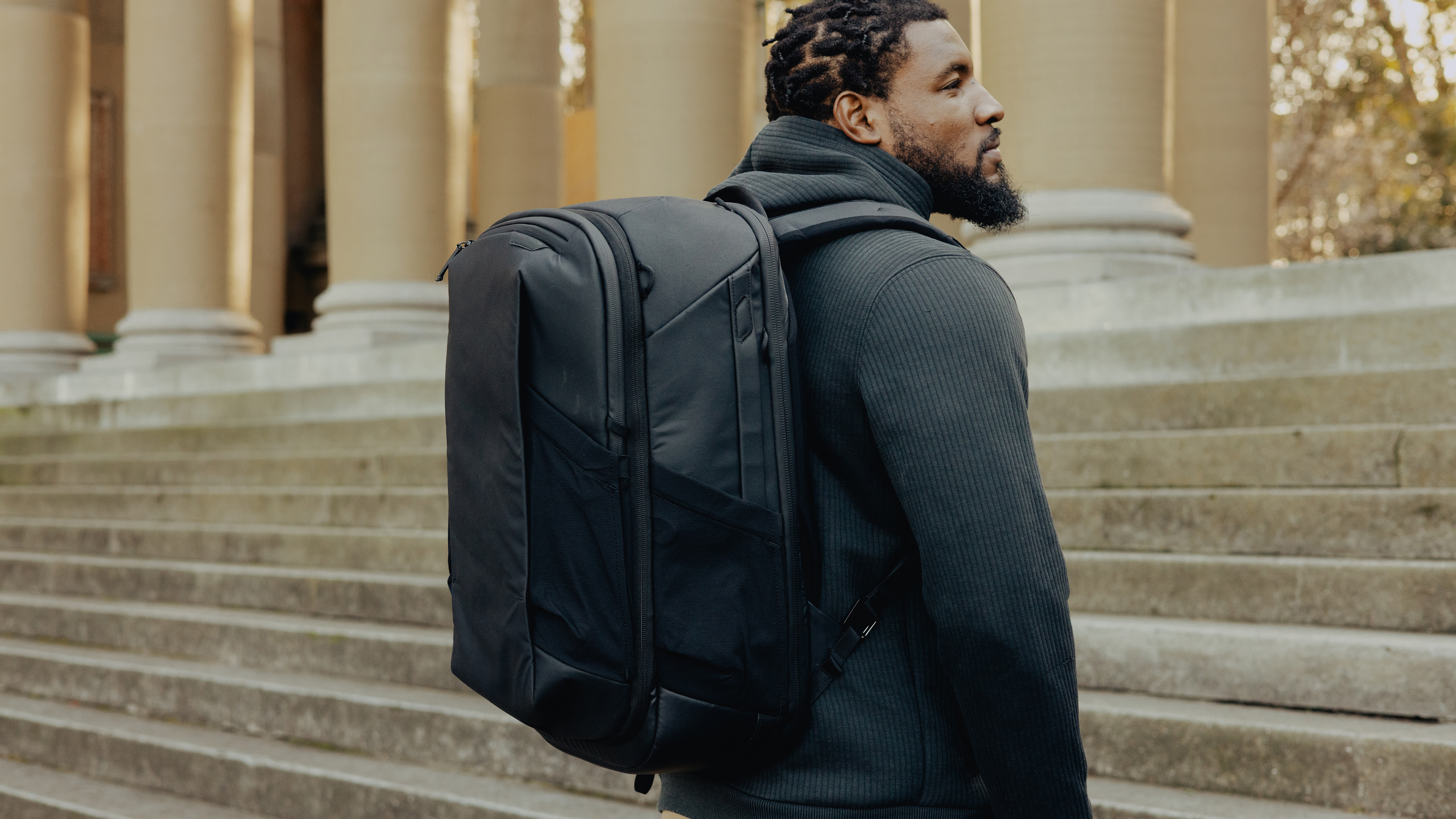 The Peak Design Travel 2-in-1 Backpack worn by a traveler