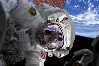 NASA astronaut Drew Morgan poses for a photo by fellow astronaut Christina Koch (visible in the reflection of Morgan's visor) during a spacewalk on Oct. 6, 2019 outside the International Space Station.