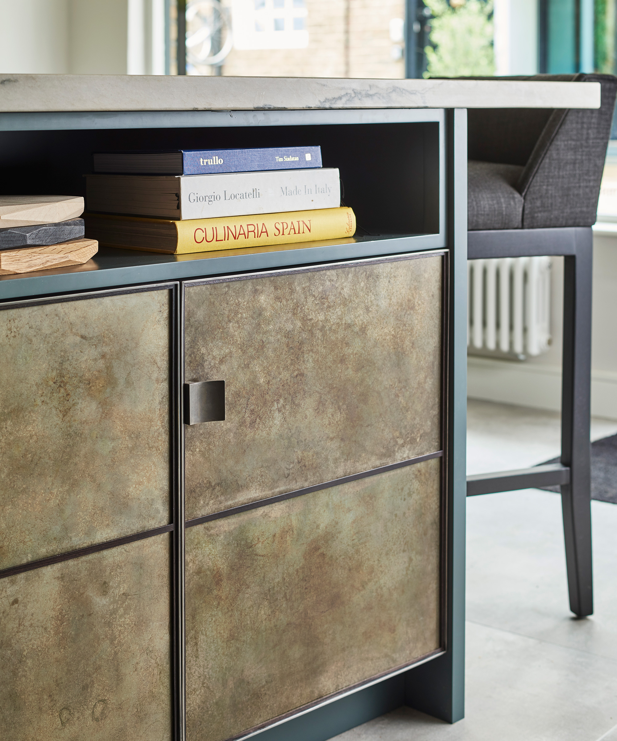 A closeup of metallic cabinets and small bookshelf