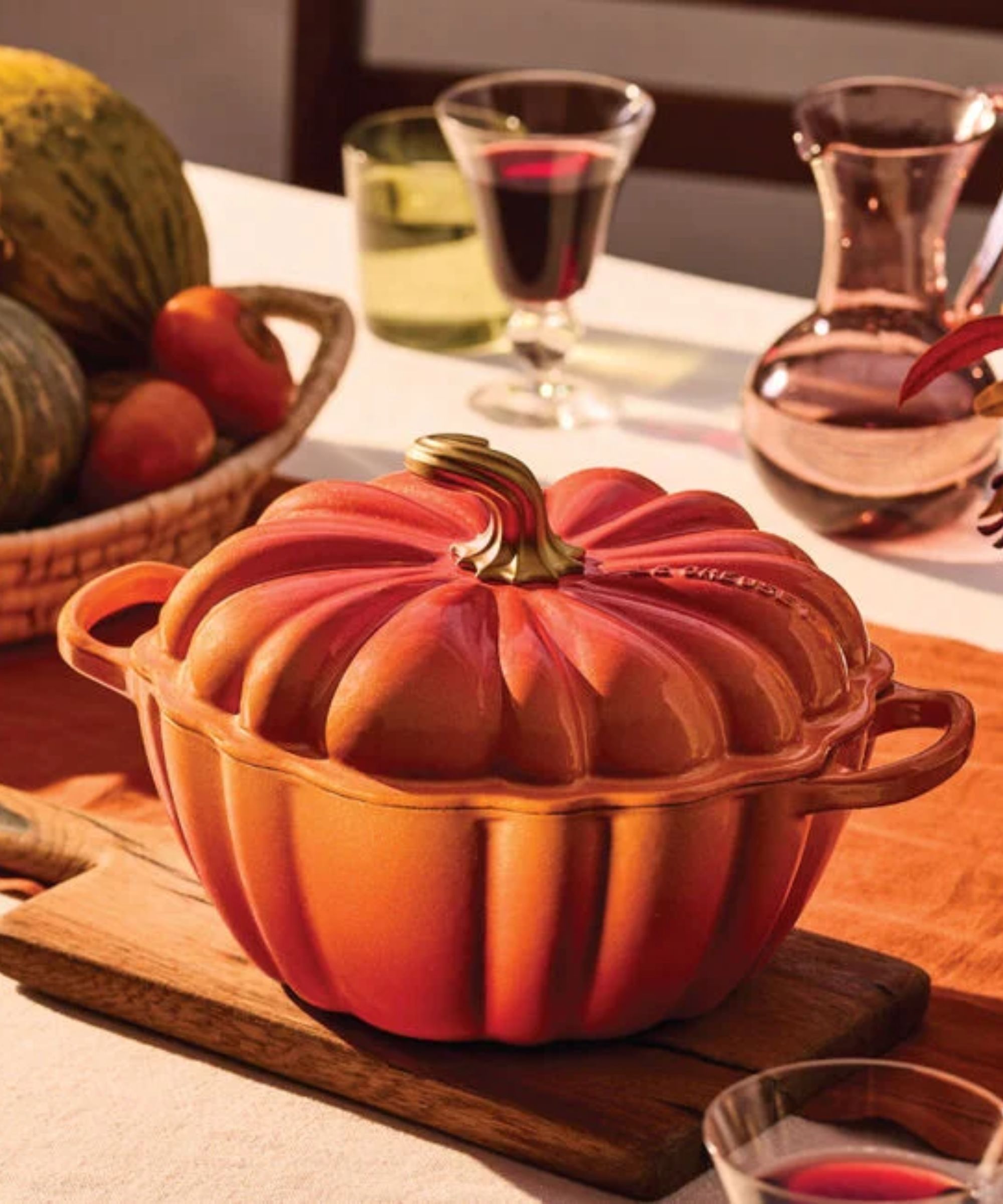 Golden orange pumpkin cocotte on wooden chopping board