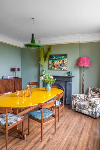 Green dining room with oval gloss yellow dining table