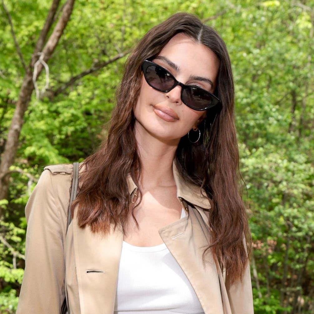 Emily Ratajkowski wearing a trench coat and white tank top