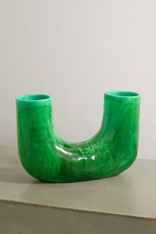 green u-shaped vase on a table