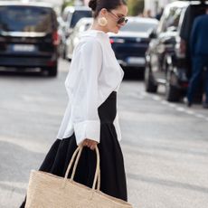 a woman wears a white shirt and a black skirt