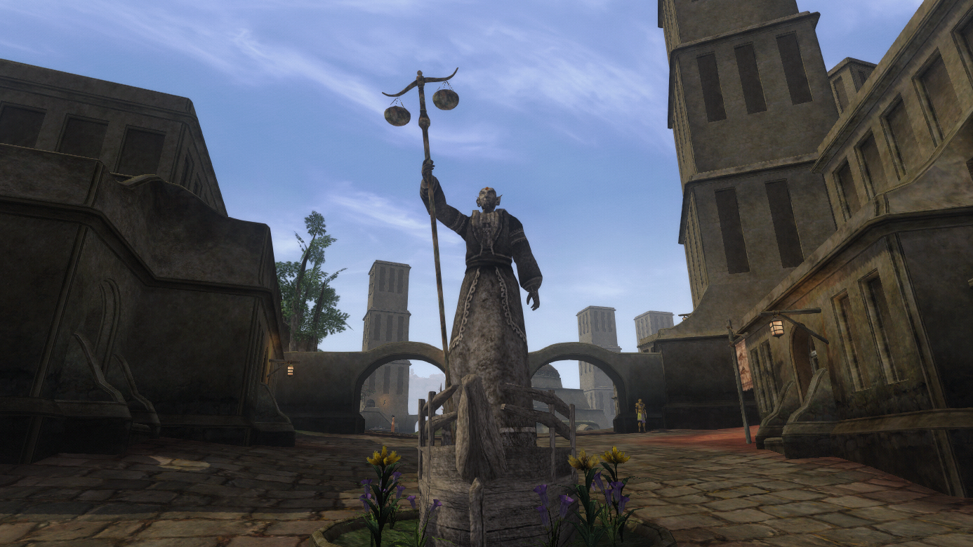 A statue holds aloft a pair of scales in a town square.