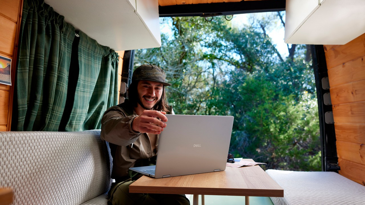 Dell 14 Plus Laptop on a desk with a happy person looking at the screen