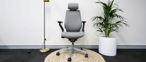 Steelcase Gesture in grey upholstery on a rug beside a floor lamp and potted plant