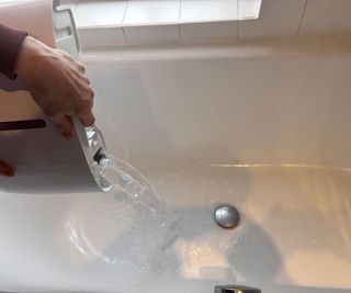 emptying a dehumidifier tank into the bath