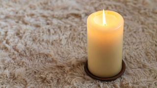 picture of lit candle on top of rug