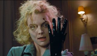 Batman Returns Michelle Pfeiffer tries her glove on for size